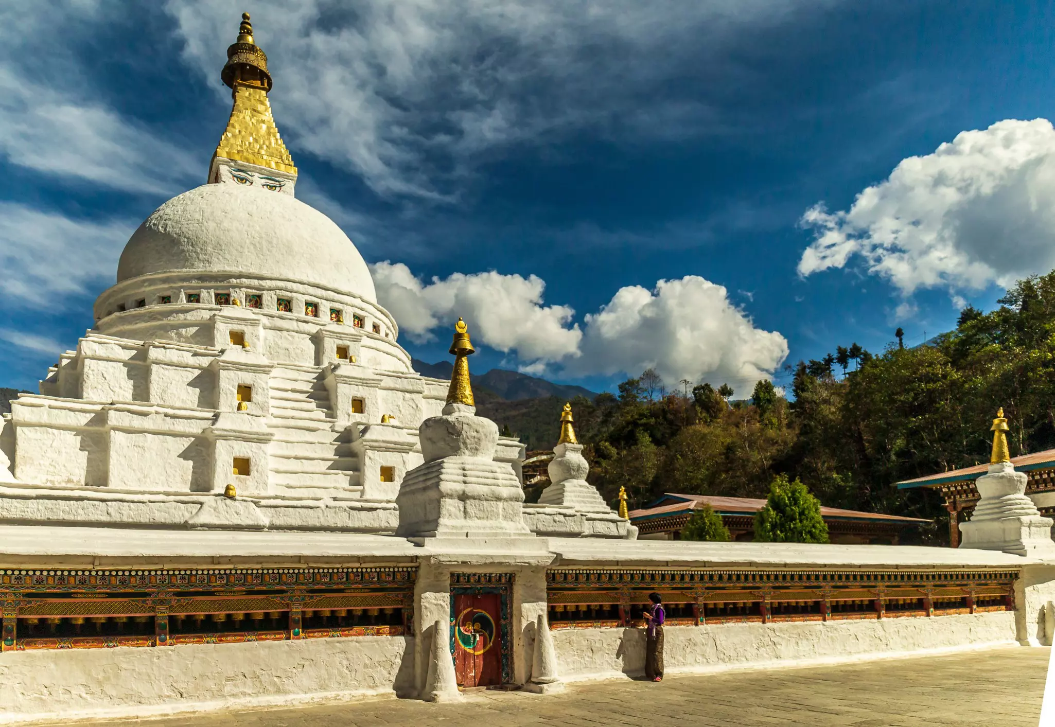 A large white chorten (stone Buddhist monument) with a gold pointed top