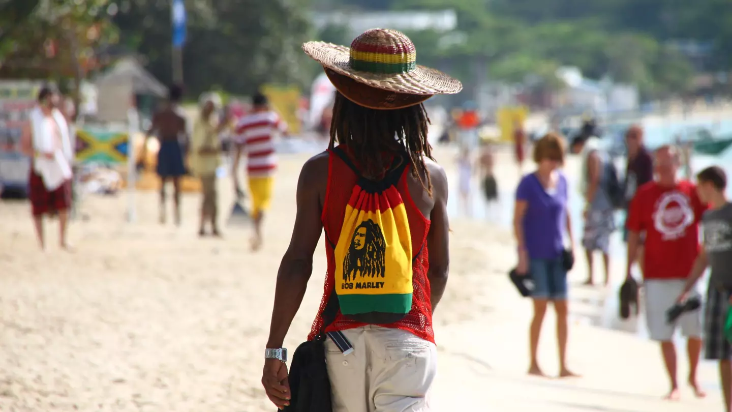 A man walking along Seven Mile Beach in Negril, Jamaica
