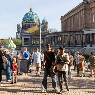 People walk near Museumsinsel. Elena Rostunova/Shutterstock