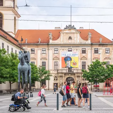 Brno, Czech Republic. Exterior of people walking past the Moravian Gallery (Moravian Museum), the second largest art museum in the Czech Republic.