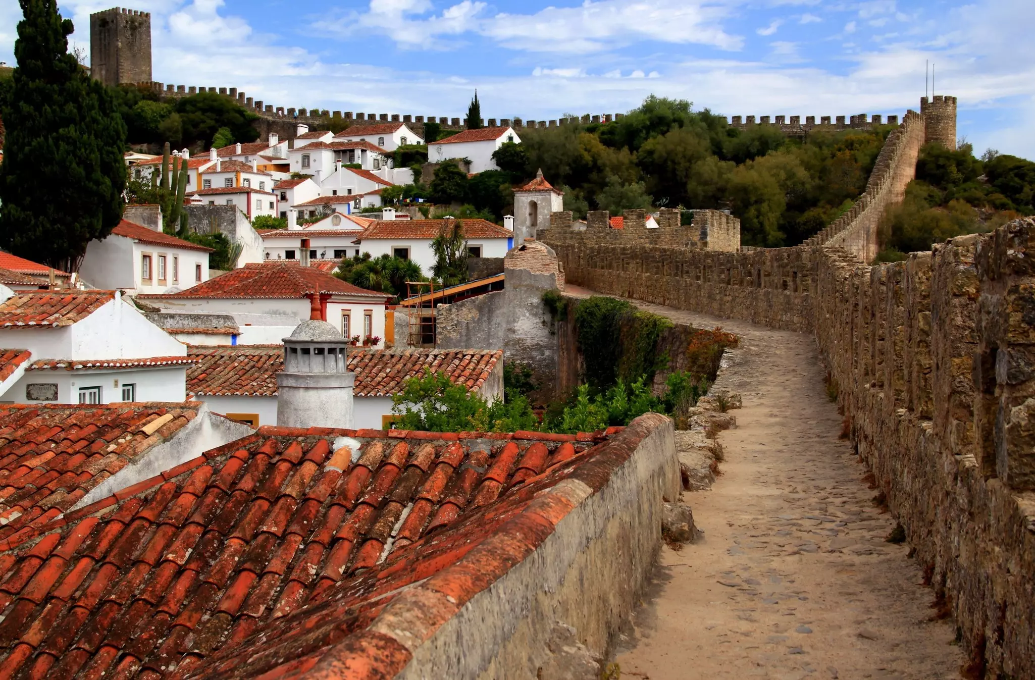 White houses with red roofs and exotic trees surrounded by the walls of Castelo de Óbidos in Obidos, Portugal, License Type: media, Download Time: 2025-11-09T23:47:02.000Z, User: LP_YKhanna, Editorial: false, purchase_order: 65050 - Digital Destinations and Articles, job: LP, client: App Content, other: Yuvraj Khanna