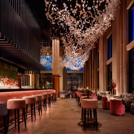 A restaurant dining room with a decorative installation hanging from the ceiling. 