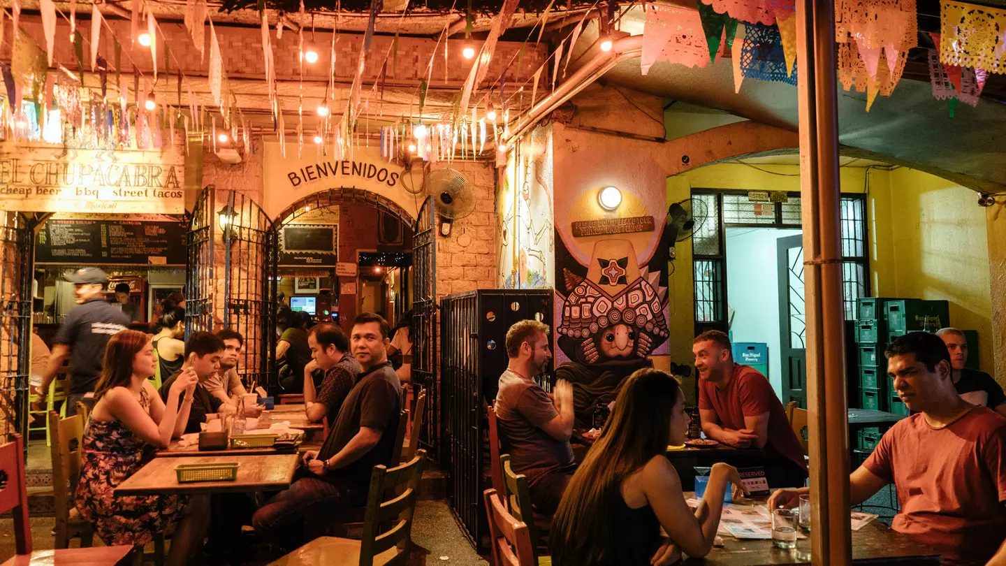 People seated at tables inside Poblacion.