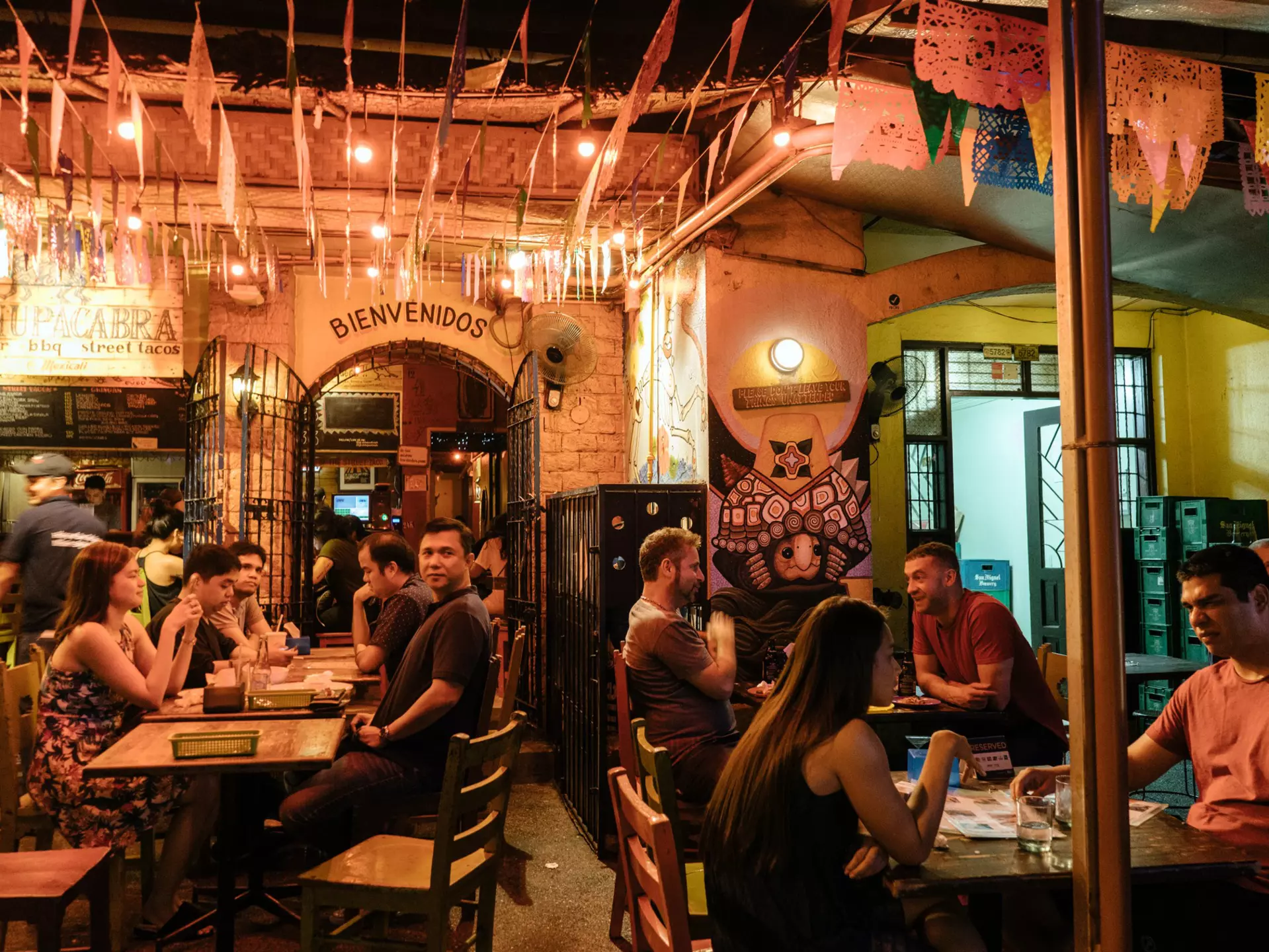 People seated at tables inside Poblacion.