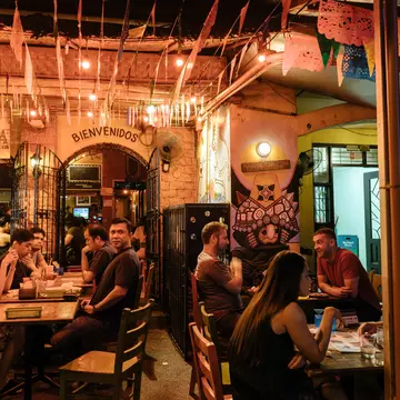 People seated at tables inside Poblacion.