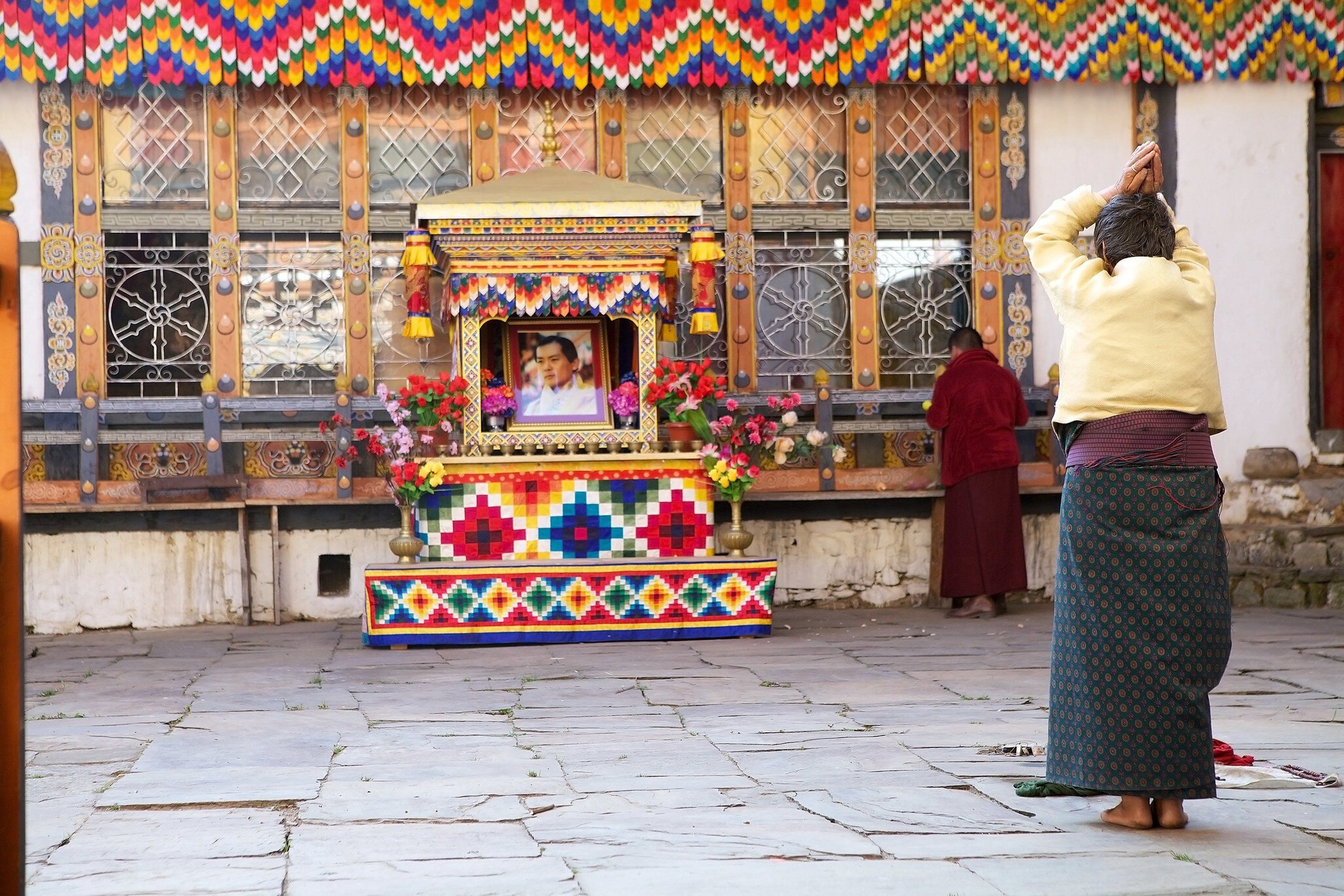 Chhoekhor, Bhutan - November 9, 2015: Pilgrim is praying at the Jampey Lhakhang temple, Chhoekhor, Bhutan with the image of the 5th King of Bhutan in the background. It is one of the oldest temple in Bhutan. It is said to date back to 7th century