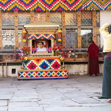 Chhoekhor, Bhutan - November 9, 2015: Pilgrim is praying at the Jampey Lhakhang temple, Chhoekhor, Bhutan with the image of the 5th King of Bhutan in the background. It is one of the oldest temple in Bhutan. It is said to date back to 7th century