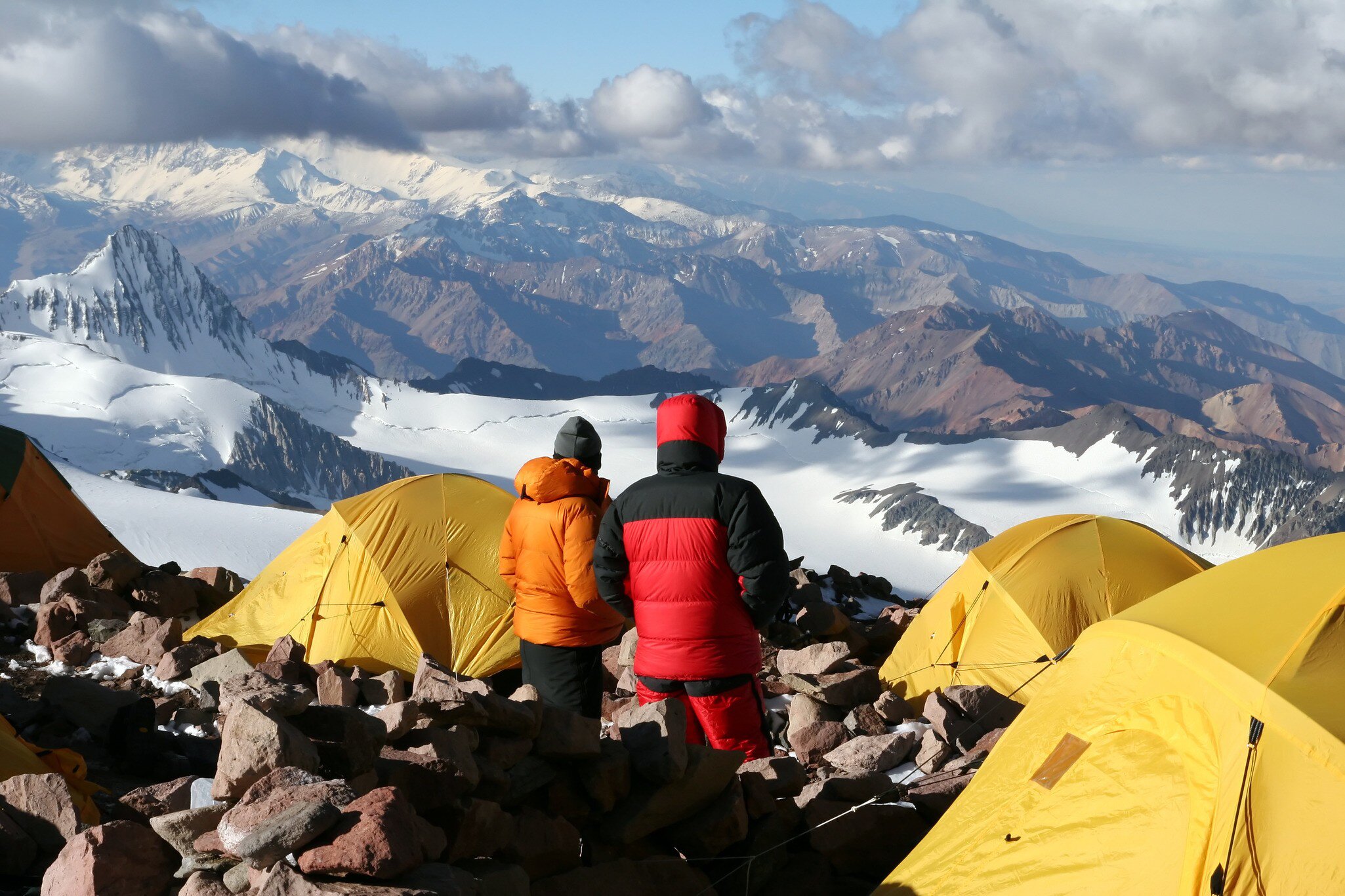 Alpine climbers acclimating at camp two of Aconcagua with bright yellow tents. Parque Provincial Aconcagua, Argentina.