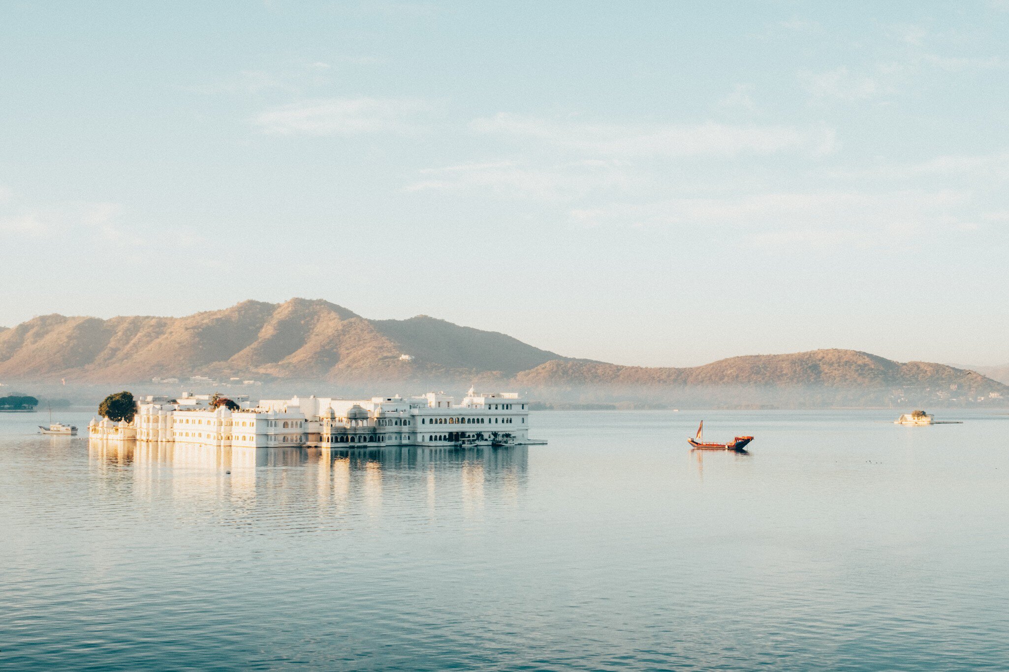 Wide view of Taj Lake Palace on the water in Udaipur, Rajasthan, India.
