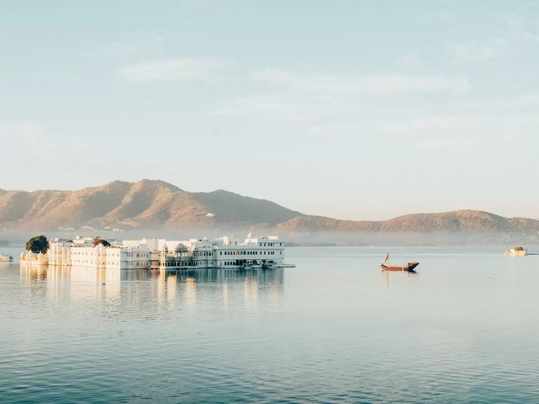 Wide view of Taj Lake Palace on the water in Udaipur, Rajasthan, India.
