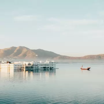 Wide view of Taj Lake Palace on the water in Udaipur, Rajasthan, India.