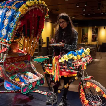 Artist Daya Bhatti puts the finishing touches to a decorated rickshaw artwork which forms part of the South Asia Gallery of Manchester Museum © OLI SCARFF/AFP via Getty Images