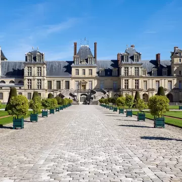 Planter Lined Cobble Stone Pathway Leading to Chateau Fontainebleau, France - stock photo
