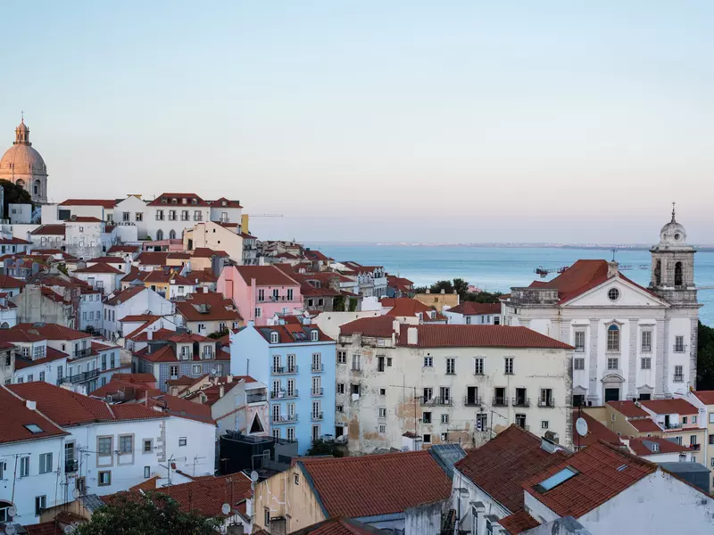 An evening scene of the rooftops of Lisbon.