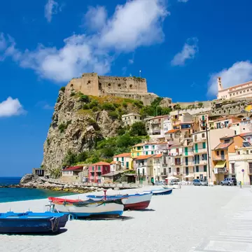 Medieval Castello Ruffo on a rocky promontory over pastel houses and fishing boats on Scilla's beach, Calabria