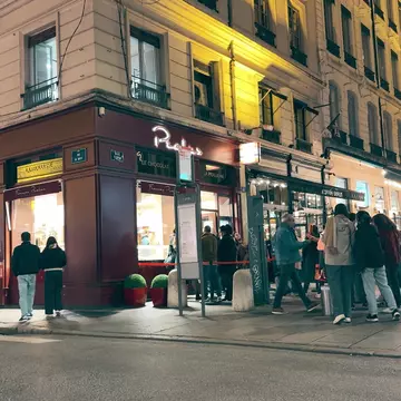 Evening street scene near famous Pralus bakery and patisserie in Lyon, France.