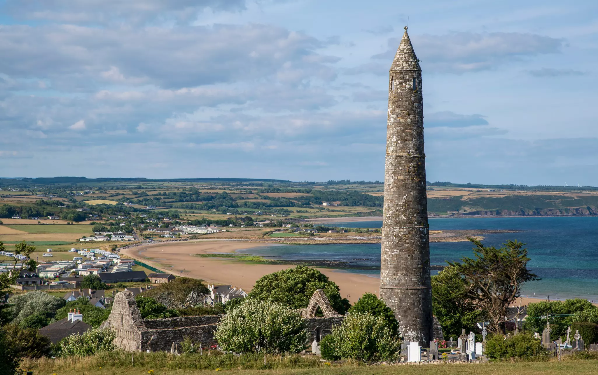 A stone tower and some buildings along the coastline in Waterford, Ireland. 