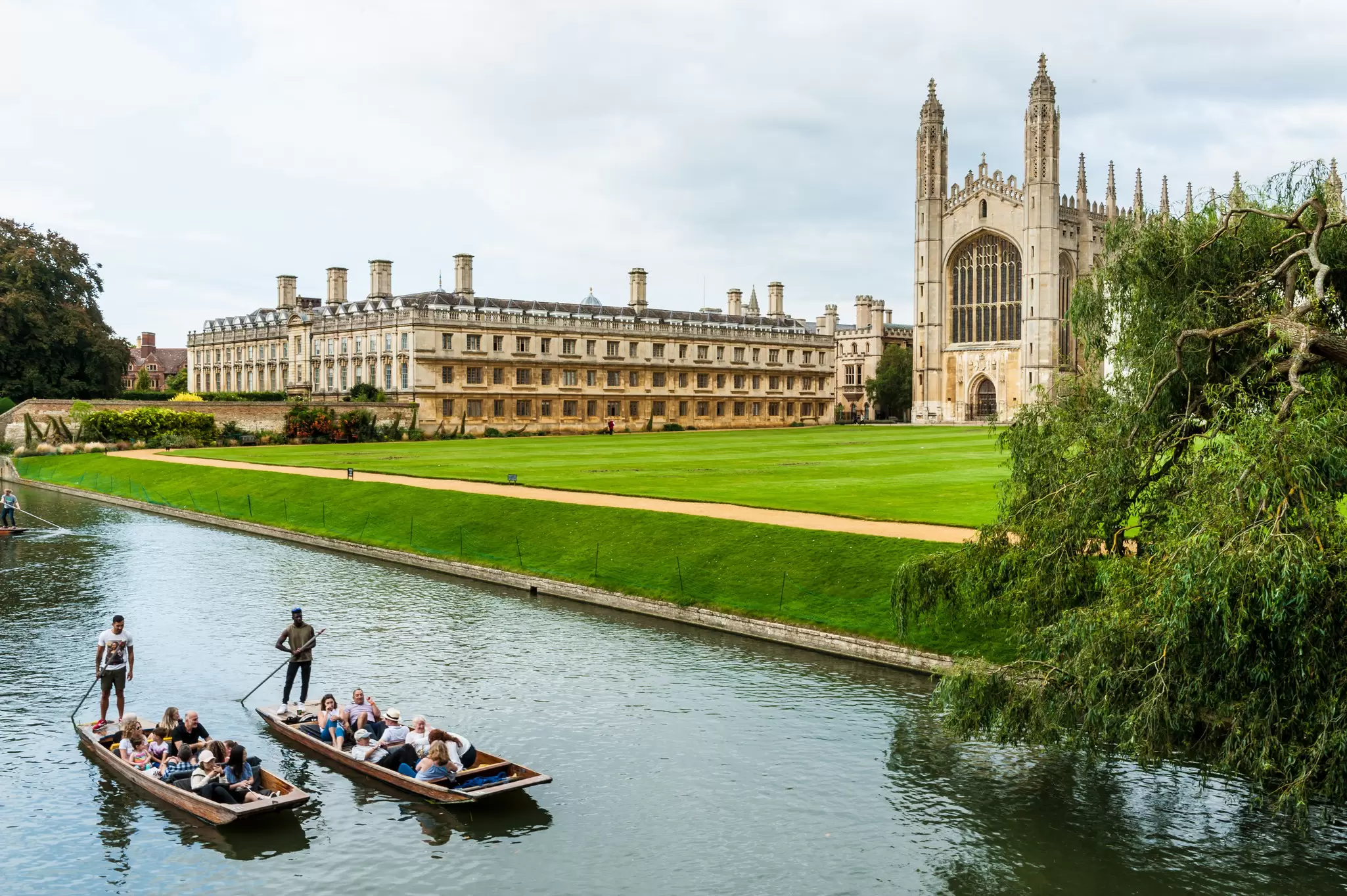 View of two boats passing along the river by King's College and King's College Chapel at Cambridge University, UK.