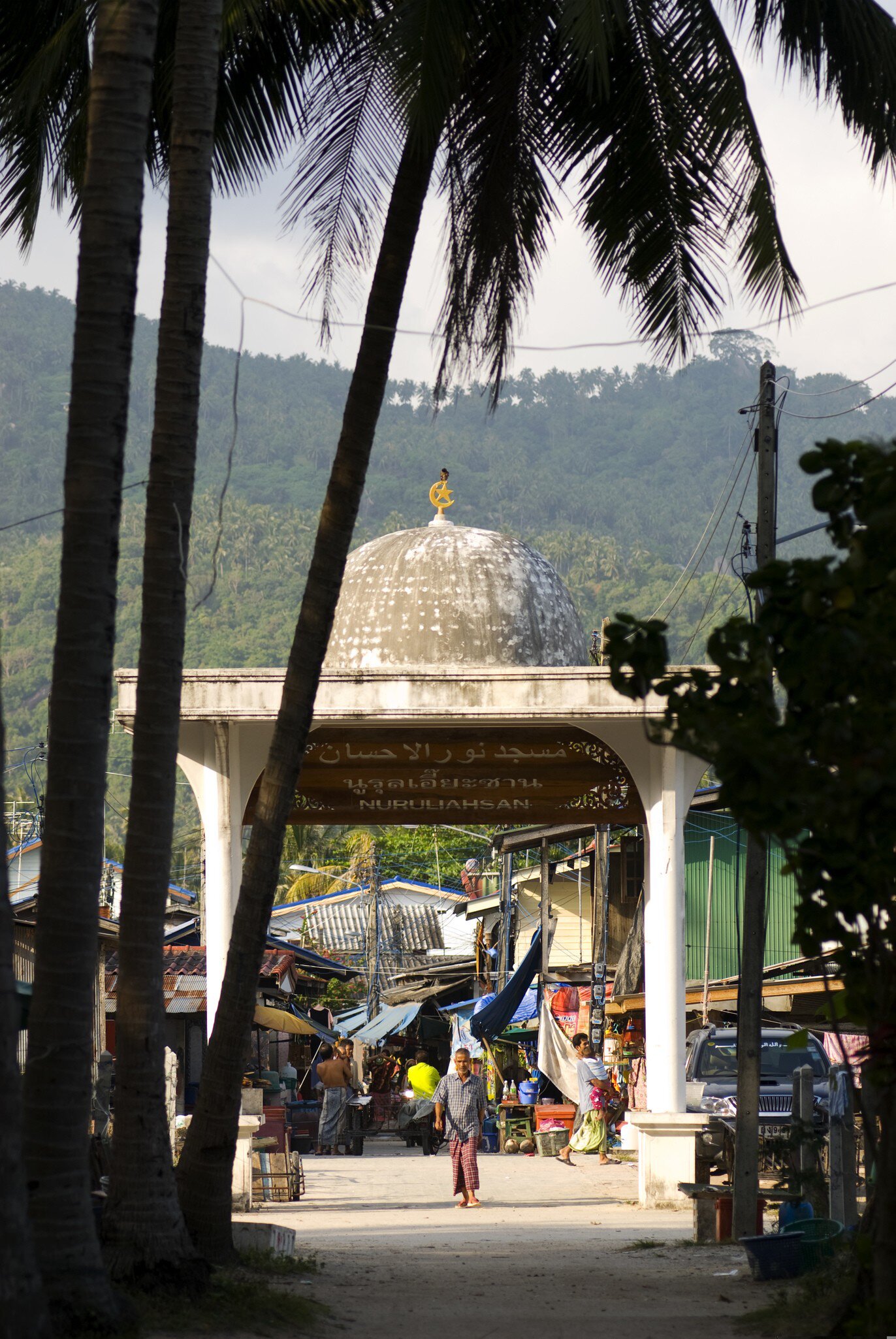 Man walking through gateway to mosque at Muslim fishing village of Ban Hua Thanon in Ko Samui, Thailand. 