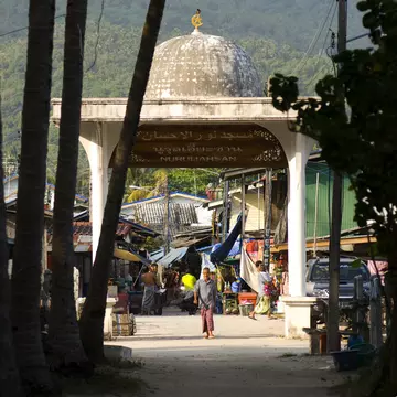 Man walking through gateway to mosque at Muslim fishing village of Ban Hua Thanon in Ko Samui, Thailand. 