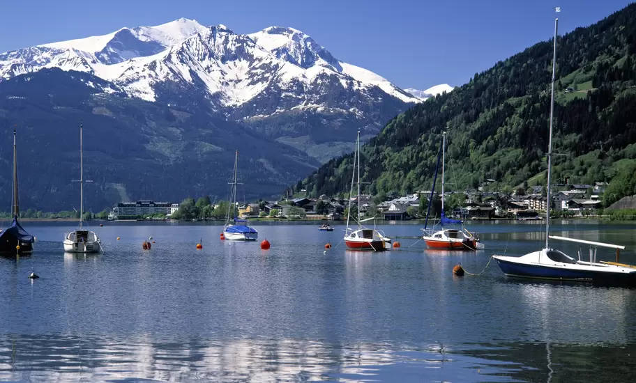 Sailboats moored on Lake Zell at Zell am See, Austria, with the lakeside town and snow-capped Alps behind
