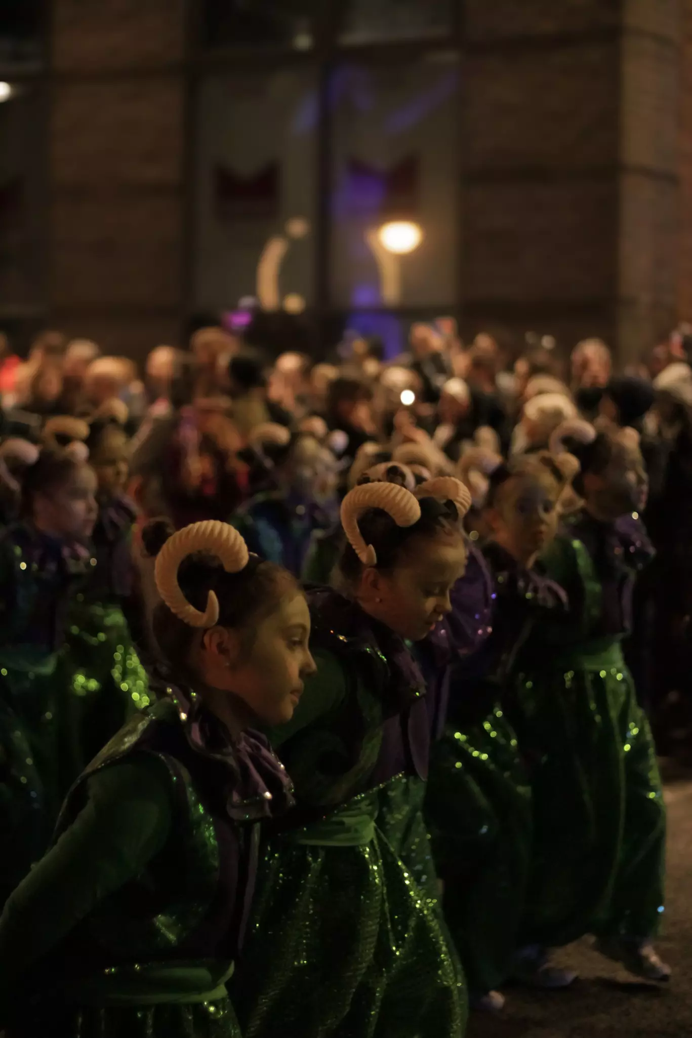 Children in a parade wear costumes with horns on their heads.