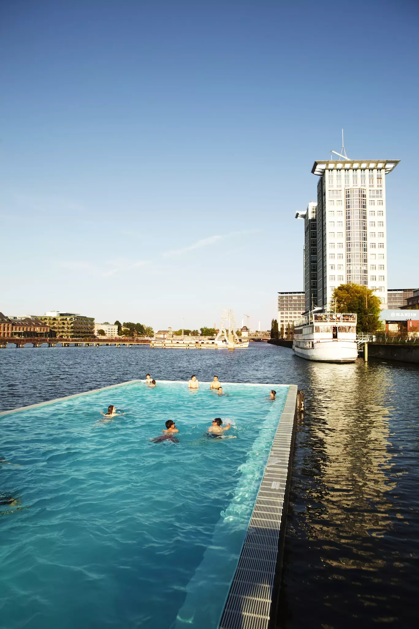 People swim at Badeschiff swimming barge on River Spree.