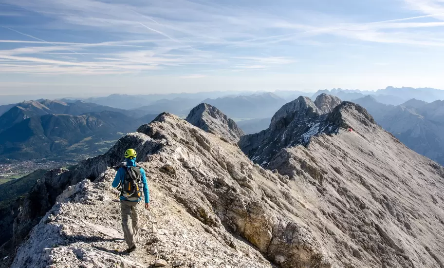 Rear View Of Hiker Walking On Mountain