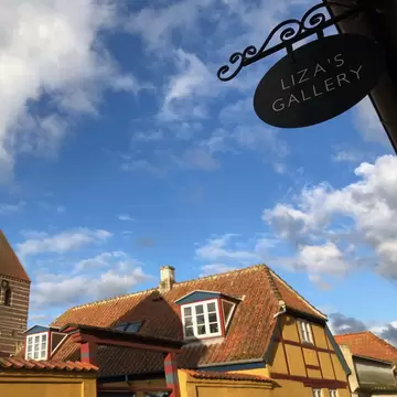 Low angle of the "Liza's Gallery" sign with blue sky. Liza's Gallery in Stege, Møn, Denmark.