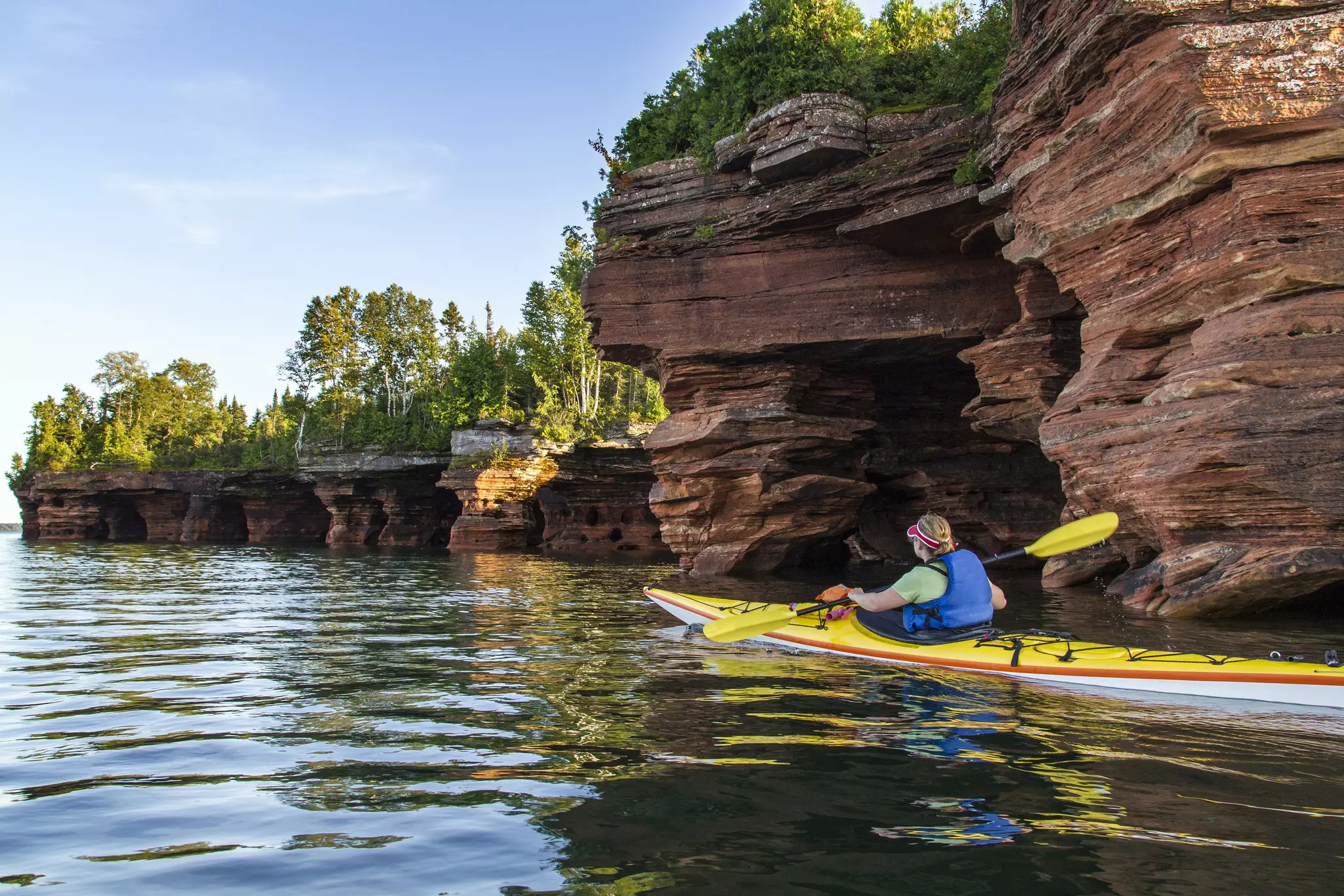 Kayaker exploring sea caves of Devils Island in Apostle Islands National Lakeshore, Wisconsin