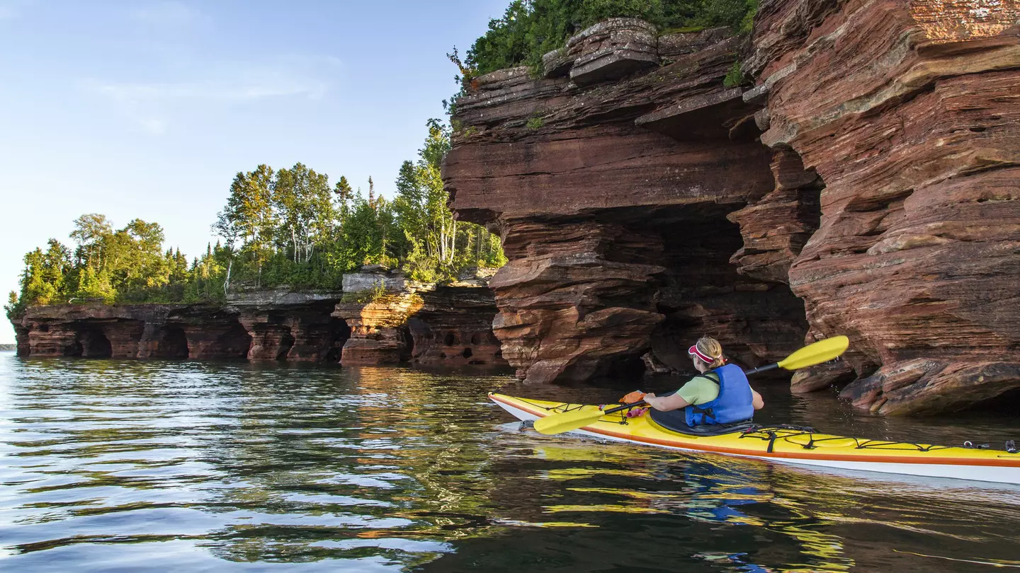 Kayaker exploring sea caves of Devils Island in Apostle Islands National Lakeshore, Wisconsin