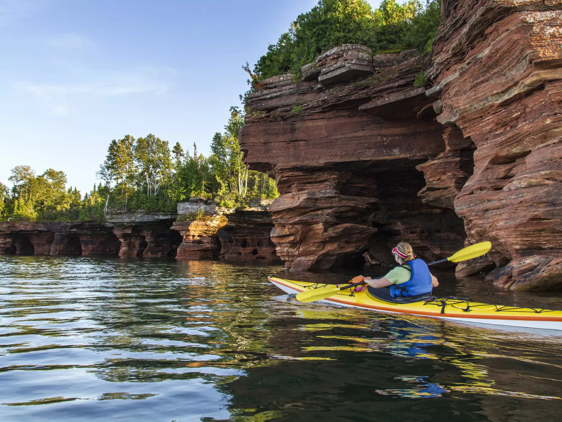 Kayaker exploring sea caves of Devils Island in Apostle Islands National Lakeshore, Wisconsin