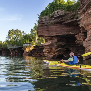 Kayaker exploring sea caves of Devils Island in Apostle Islands National Lakeshore, Wisconsin