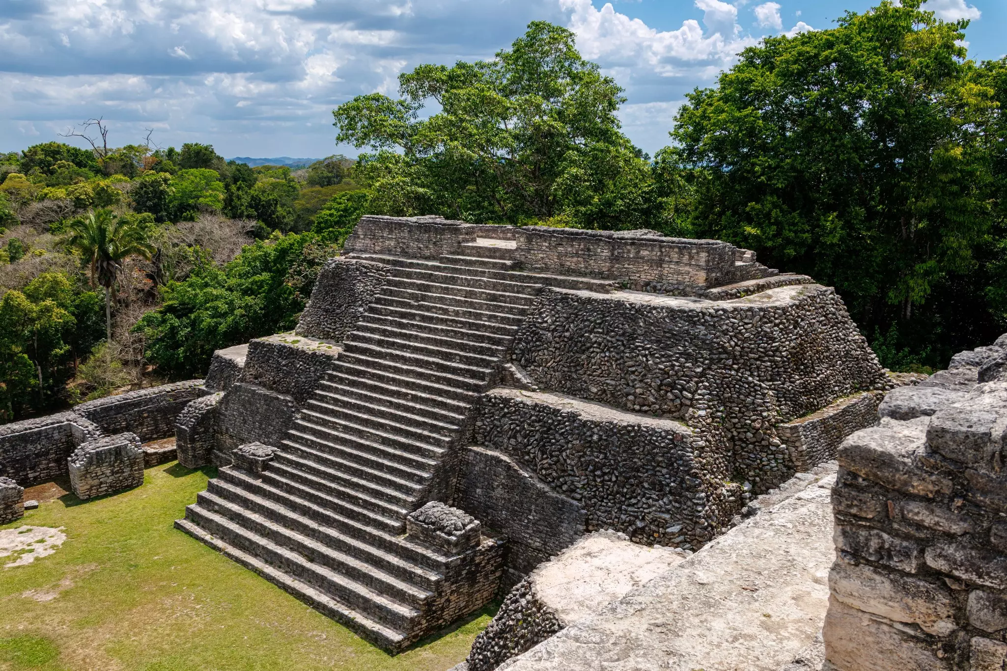 An aerial view of a monumental pyramid with a huge exterior stairway.