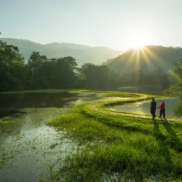 Couple walking at the pathway of 'S - Curve' in early morning at Taman Tasik Taiping, Perak, Malaysia.