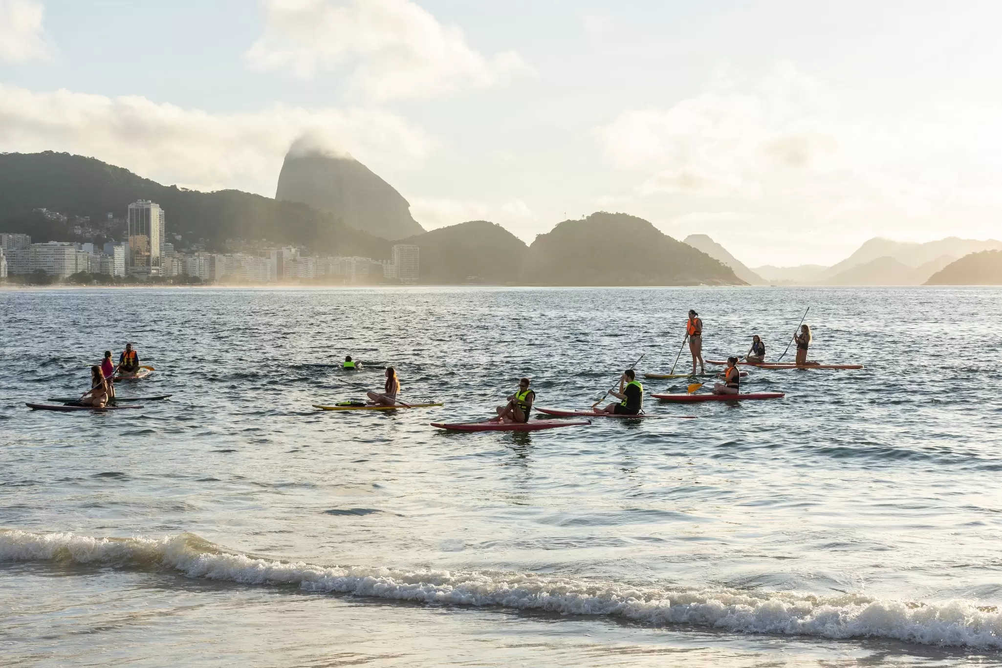 Beautiful view of a group of people paddling in the water by Copacabana Beach in Rio de Janeiro, Brazil.