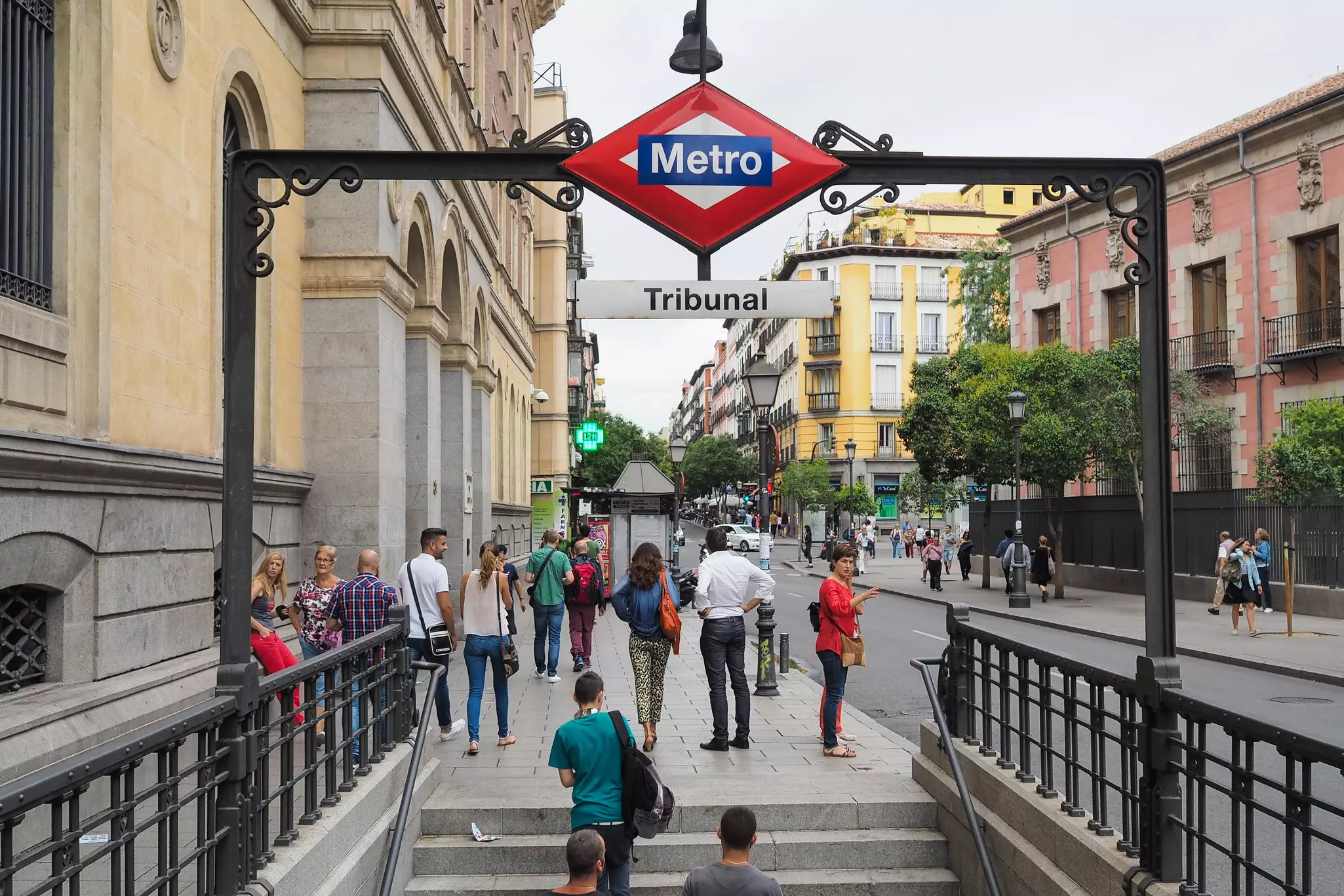People exit a metro station via the stairs and enter the city streets