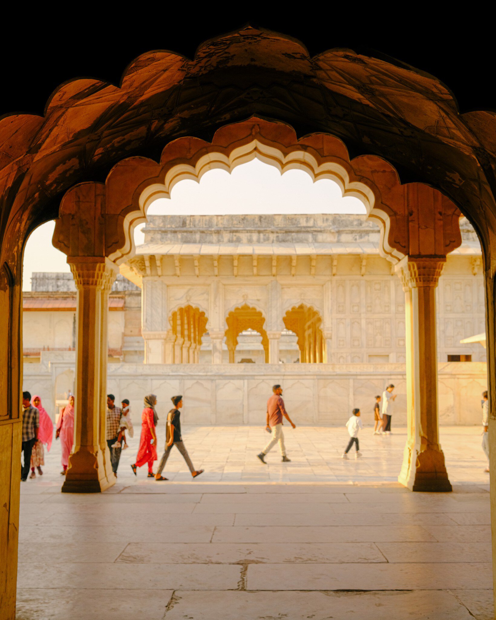 People walk through arches in Delhi, India.