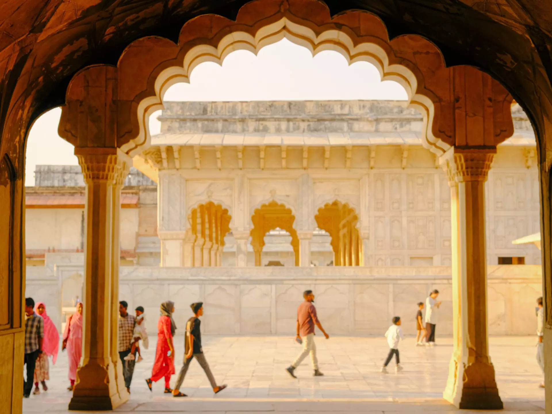 People walk through arches in Delhi, India.