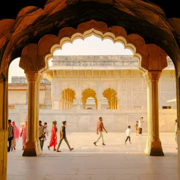 People walk through arches in Delhi, India.