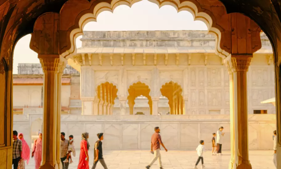 People walk through arches in Delhi, India.