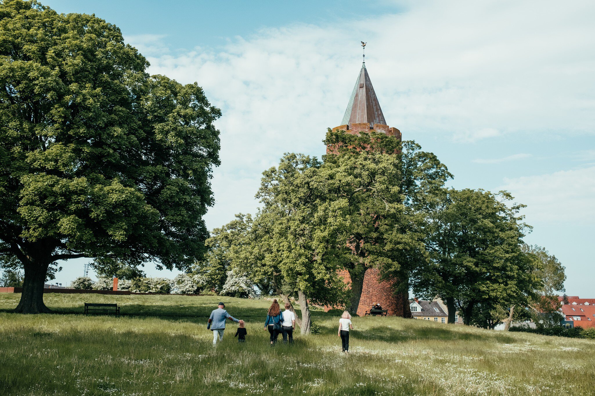 A family walking up to Danmarks Borgcenter in Zealand, Denmark. Surrounded by greenery.
