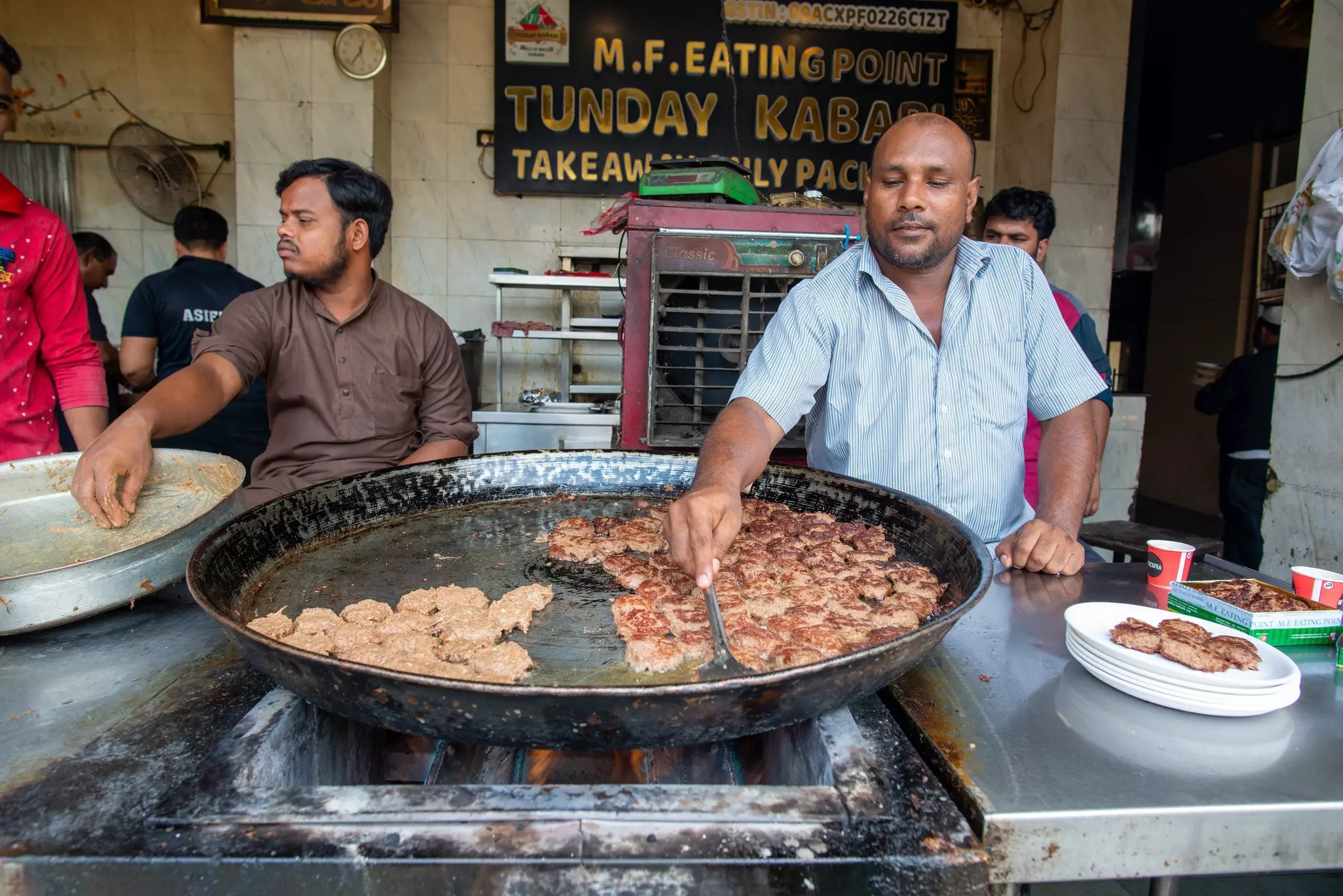 A cook frying kebabs in a traditional pan in Lucknow