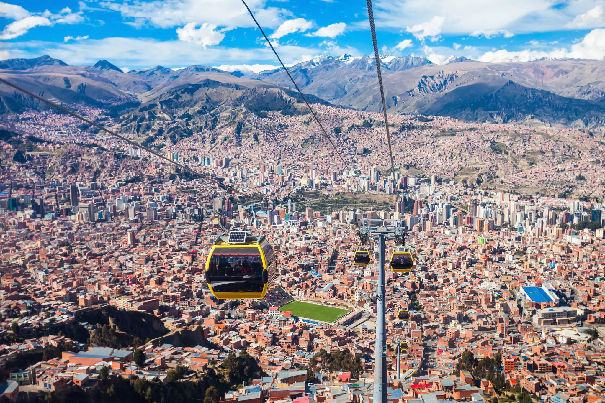 A cable car system over a dense mountain city.