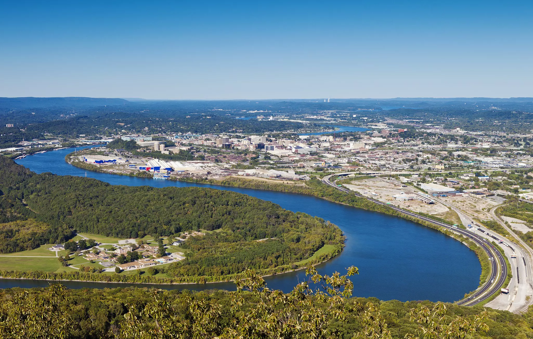 A river curves through the landscape with a city near one of its bends.