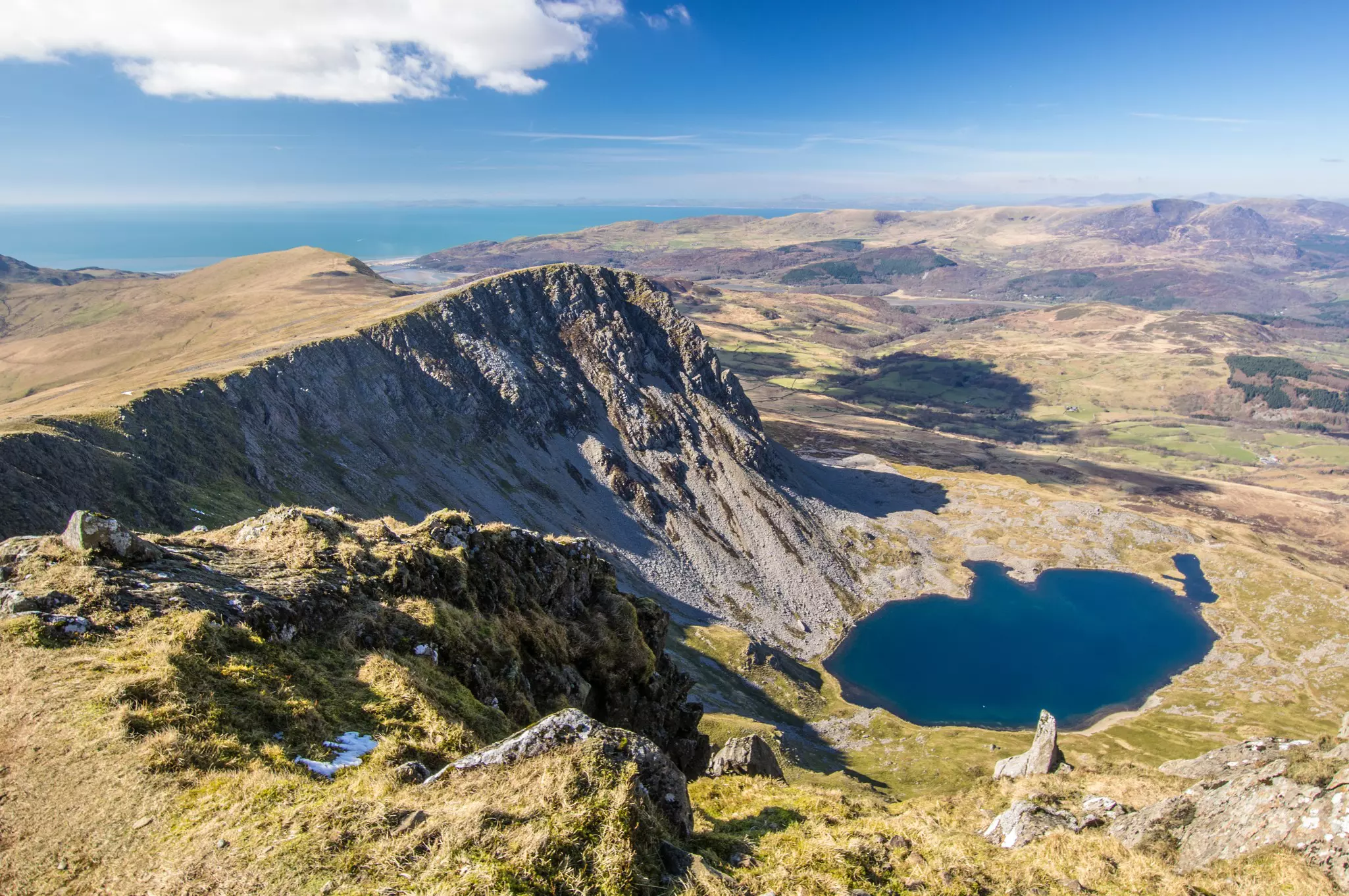 View from Cadair Idris (Penygader or Cader Idris) mountain: lake Llyn y Gader, and Irish sea at the horizon. Wales, at the southern end of the Snowdonia National Park near the town of Dolgellau