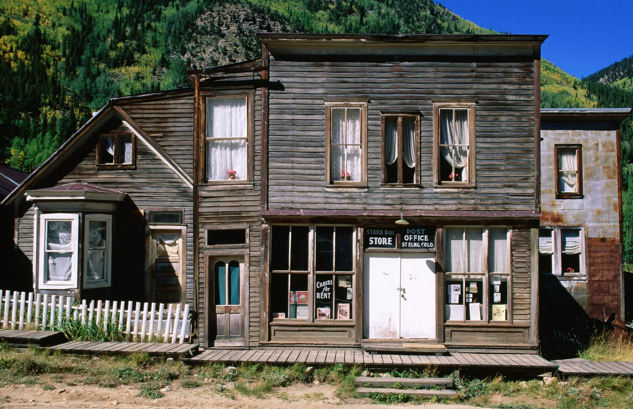 The exterior of a historic wooden-boarded post office building in an abandoned town