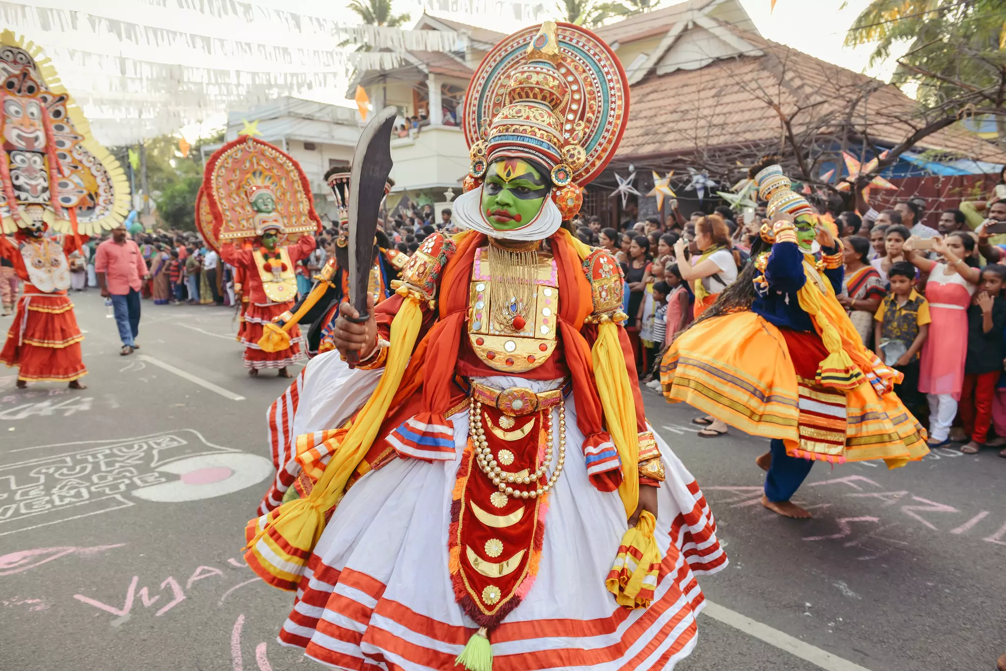 Heavily costumed Kathakali performers walk the streets of Fort Kochin. Kochi, India.