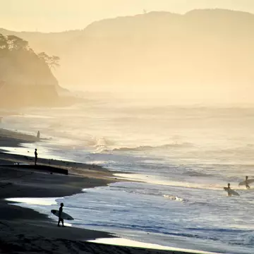 Surfers on the beach at Kamakura. Taro Hama. e-kamakura / Getty Images