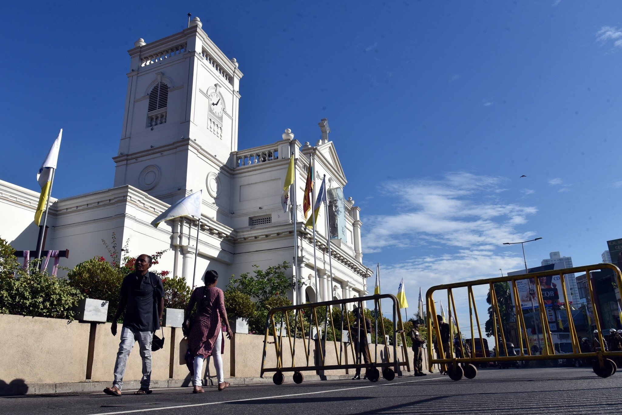 Low-angle view of two people walking past St. Anthony’s Shrine in Kochchikade, Colombo, Sri Lanka.